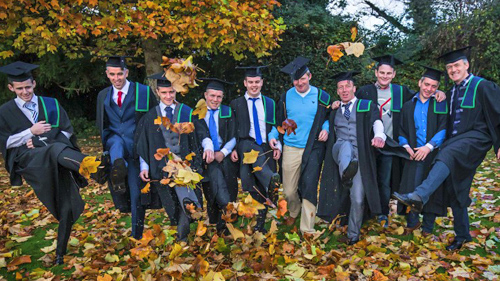 A photo of a group of graduates all smiles after receiving their qualifications